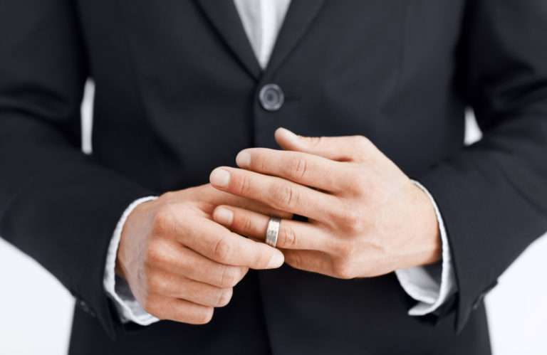 мужчина снимает с руки кольцо